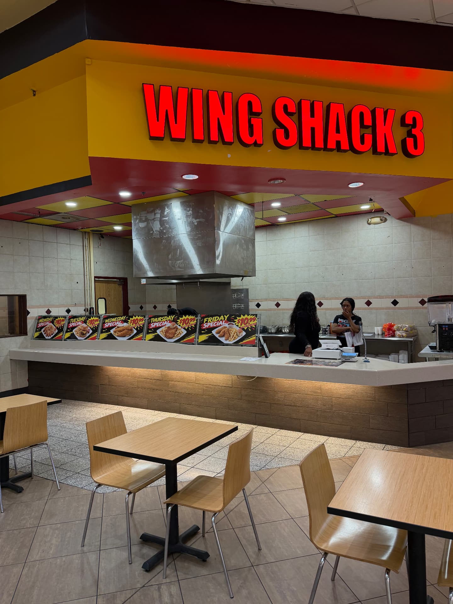Inside the Wingshack 3 counter, with the illuminated red sign above the ordering area